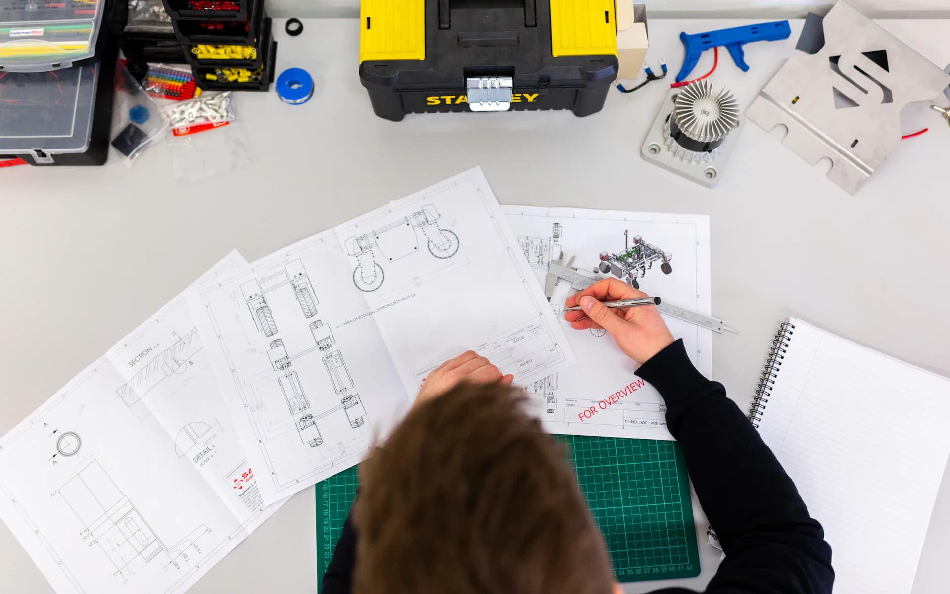 Engineering plans and tools on a workbench as a design is developed.